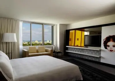 a hotel room with a bed and a flat screen tv at Mondrian South Beach in Miami Beach
