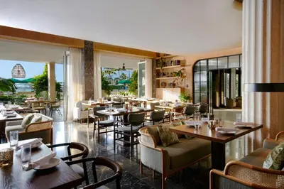 a restaurant with tables and chairs in a room at Mondrian South Beach in Miami Beach