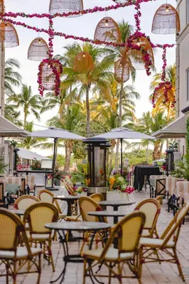 a patio with tables and chairs and palm trees at Hotel Ocean in Miami Beach