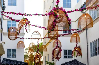 a string of bird cages hanging from a building with christmas lights at Hotel Ocean in Miami Beach