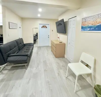 a living room with a black couch and a white chair at Cozy Private House near Miami Airport - Free parking - 01 in Miami