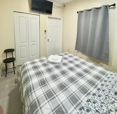 a bedroom with a bed with a plaid blanket at Cozy Private House near Miami Airport - Free parking - 01 in Miami