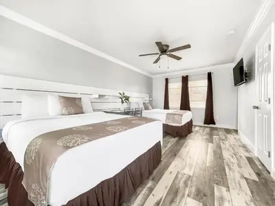 a bedroom with two beds and a ceiling fan at Neptune Oceanfront Rentals in Hollywood