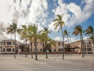 a row of palm trees in front of a building at Neptune Oceanfront Rentals in Hollywood