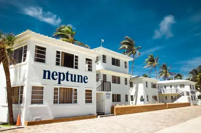 a white building with the words neptune on it at Neptune Oceanfront Rentals in Hollywood