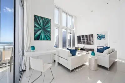 a living room with white furniture and a large window at ICONIC LUXURIOUS HIGH CEILINGS UNIT BRICKELL w in Miami
