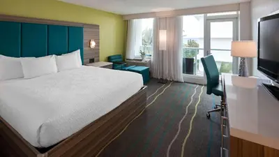 a hotel room with a bed and a television at Best Western Plus Oceanside Inn in Fort Lauderdale
