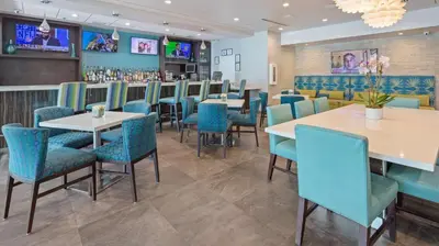 a restaurant with tables and chairs and a bar at Best Western Plus Oceanside Inn in Fort Lauderdale
