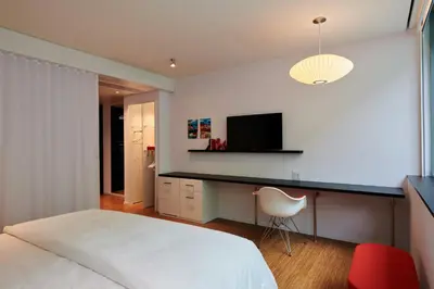 a bedroom with a bed and a desk with a television at citizenM Miami World Center in Miami