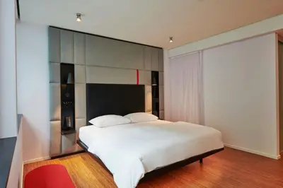a bedroom with a large white bed with a headboard at citizenM Miami World Center in Miami