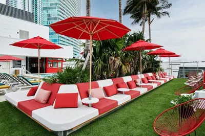 a row of red and white chairs and umbrellas at citizenM Miami World Center in Miami