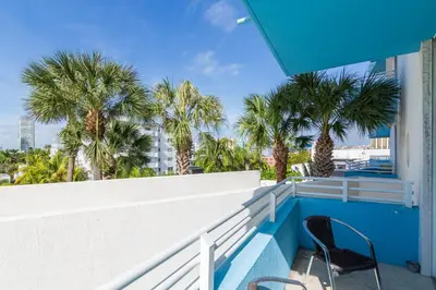 a balcony with two chairs and palm trees at Dream Destinations at Ocean Place in Miami Beach