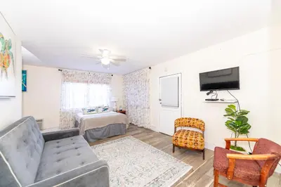 a living room with a couch and a tv at Tropic Isle Hotel & Apartment in Hollywood