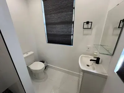 a white bathroom with a toilet and a sink at Pretty Private Room, near the Airport - Free parking - 01 in Miami