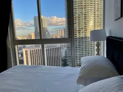 a bedroom with a white bed and a large window at IconBrickell Tower 3 W Residences in Miami