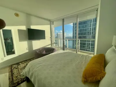 a bedroom with a large bed and a large window at IconBrickell Tower 3 W Residences in Miami