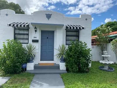 a white house with a blue door at Gorgeous Private Room, near the Airport - Free parking - 01 in Miami