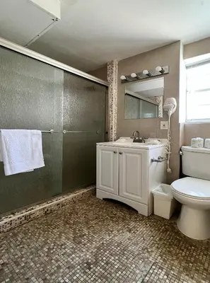 a bathroom with a sink and a toilet and a mirror at South of Fifth Ocean Drive Apt in Miami Beach