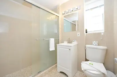 a bathroom with a toilet and a glass shower at South of Fifth Ocean Drive Apt in Miami Beach