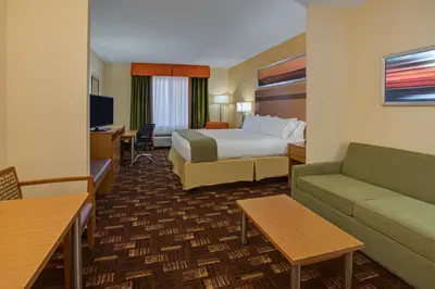 a hotel room with a bed and a couch at Holiday Inn Express Fort Lauderdale Airport South by IHG in Dania Beach