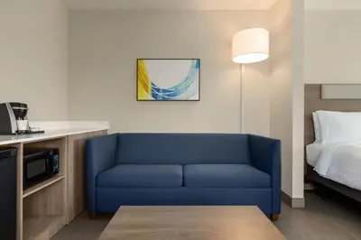 a living room with a blue couch in a hotel room at Holiday Inn Express Fort Lauderdale Airport South by IHG in Dania Beach
