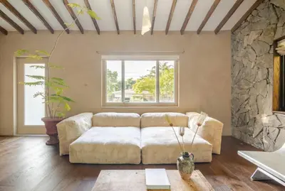 a living room with a couch and a stone wall at Casa Ishi - at lumicollection in Miami