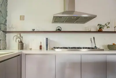 a kitchen with white cabinets and a stove top oven at Casa Ishi - at lumicollection in Miami