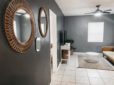 a living room with a mirror and a couch at Lovely Bohemian Apartment in Fort Lauderdale