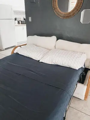 a bed with a black and white comforter in a room at Lovely Bohemian Apartment in Fort Lauderdale