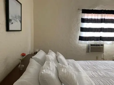 a bedroom with a bed with white pillows and a window at Cozy Private Room, near the Airport - Free parking - 01 in Miami