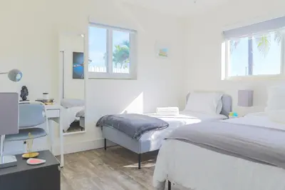 a bedroom with two beds and a chair and a mirror at MIAMI PARADISE in Miami