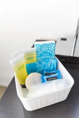 a container filled with toothbrushes and a drink on a counter at MIAMI PARADISE in Miami