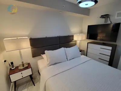 a bedroom with a bed and a flat screen tv at Deluxe Beach Resort - HORA RENTALS in Miami Beach