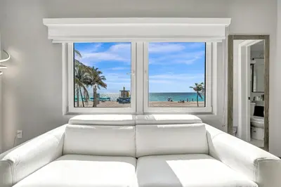 a white couch in front of a window with a view of the beach at Hotel Sheldon in Hollywood