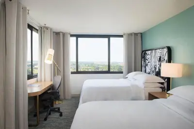 a hotel room with two beds and a desk and a window at Sheraton Miami Airport Hotel and Executive Meeting Center in Miami