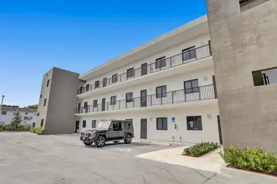 a truck parked in a parking lot in front of a building at Renzzi Wynwood Apartments in Miami