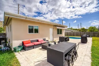 a patio with a table and chairs and a couch at Tranquil Retreat with HEATED POOL Minutes to the Beach in Dania Beach