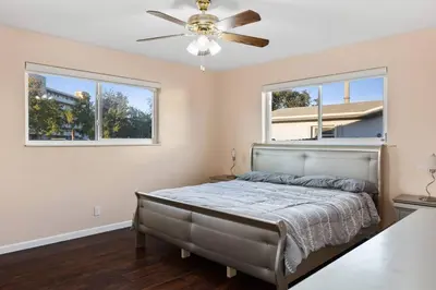 a bedroom with a bed with a ceiling fan at Tranquil Retreat with HEATED POOL Minutes to the Beach in Dania Beach