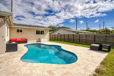 a swimming pool in the backyard of a house at Tranquil Retreat with HEATED POOL Minutes to the Beach in Dania Beach