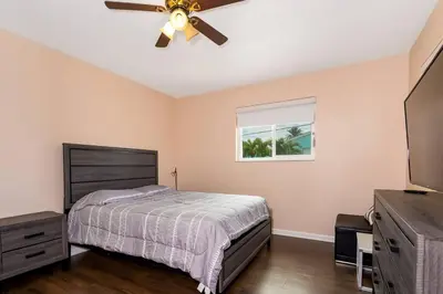 a bedroom with a bed and a ceiling fan at Tranquil Retreat with HEATED POOL Minutes to the Beach in Dania Beach