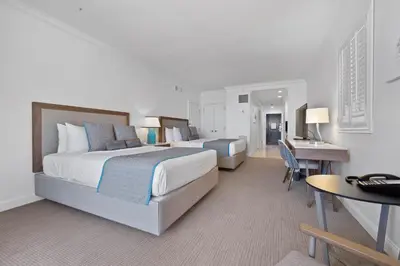 a hotel room with two beds and a desk at The Atlantic Hotel & Spa in Fort Lauderdale