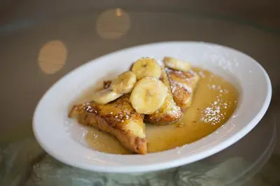 a white bowl of food with bananas and french toast at The Atlantic Hotel & Spa in Fort Lauderdale