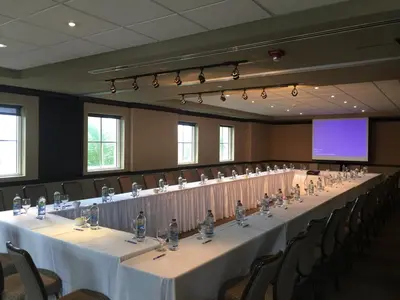 a large conference room with tables and chairs and a screen at The Atlantic Hotel & Spa in Fort Lauderdale