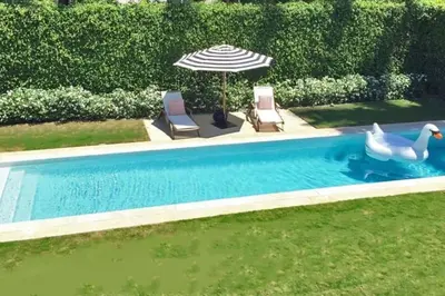 a swimming pool with two swans and an umbrella at Villa Naomi - Luxury Design New Home in Miami