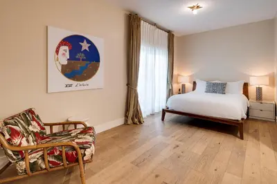 a bedroom with a bed and a chair at The Savoy Hotel & Beach Club in Miami Beach
