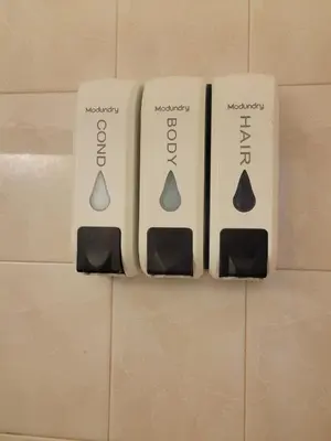 three soap dispensers on the wall of a bathroom at Welcome Heart and Reliable Heart Vacation Houses in Miami
