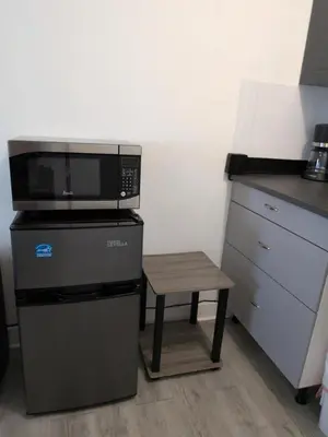 a microwave and a stool in a kitchen at Welcome Heart and Reliable Heart Vacation Houses in Miami