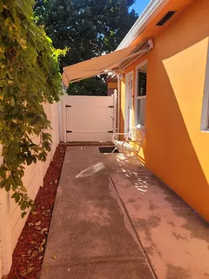a driveway leading to a garage with a white gate at Welcome Heart and Reliable Heart Vacation Houses in Miami