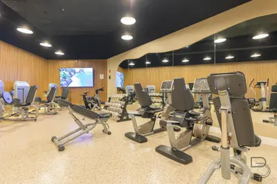 a gym with a bunch of chairs and a screen at Girasole Rentals Suites in Miami Beach