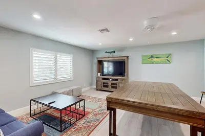 a living room with a table and a tv at Middle River Lookout in Fort Lauderdale